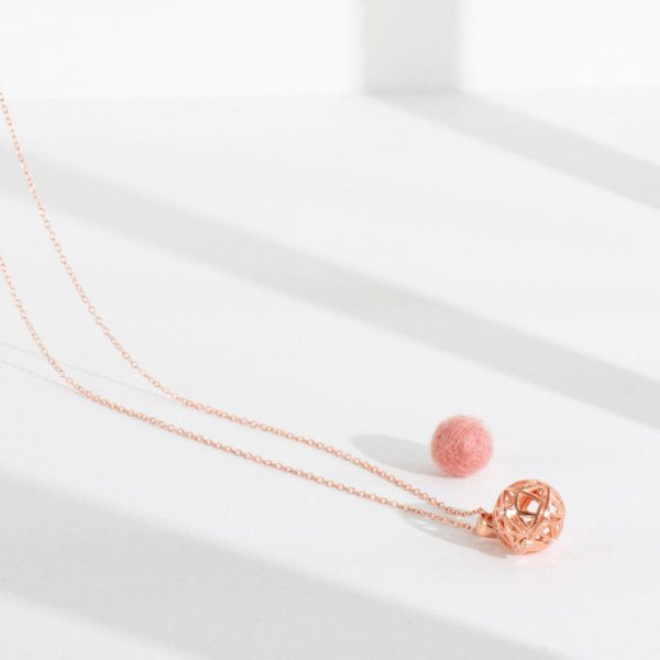 Lifestyle shot of our rose gold aromatherapy necklace with single wool-felt diffuser ball