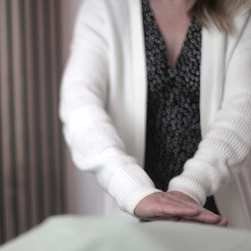 Reiki master practitioner, Chelle, carrying out a Reiki healing treatment on a client
